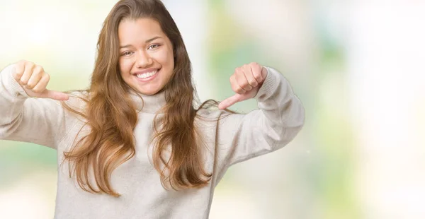 若いの美しいブルネットの女性の顔に笑顔と自信を持って 誇りと幸せな指で自分を指している孤立した背景にタートルネックのセーターを着て — ストック写真