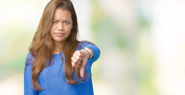 年轻美丽的黑发女人穿着蓝色毛衣在孤立的背景看起来不高兴和愤怒显示拒绝和消极与拇指向下手势 表达错误 — 图库照片