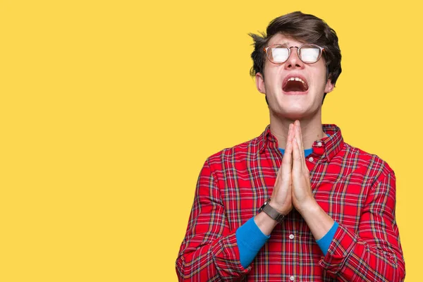 Joven Hombre Guapo Con Gafas Sobre Fondo Aislado Mendigando Rezando —  Fotos de Stock