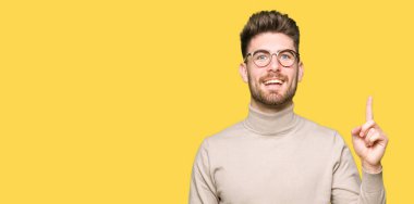 Başarılı fikirle parmağı yukarıyı gözlüklü genç yakışıklı iş adamı. Çıktıktan ve mutlu. Bir numara.