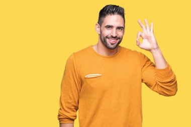 Gülümseyen izole arka plan üzerinde genç yakışıklı adam el ve parmaklar ok işaretiyle yapıyor olumlu. Başarılı ifade.