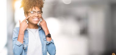 Güzel genç Afro-Amerikan kadın gözlük izole üzerinde gülen arka plan açık ağız ile parmak işaret ve neşeli gülümseme zorlamadan