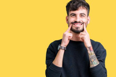 İzole genç yakışıklı adam arka plan gülen açık ağız ile parmak işaret ve neşeli gülümseme zorlamadan