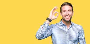 Mavi gözleri ile yakışıklı iş adamı el ve parmaklar ile ok işareti yapıyor pozitif gülümseyen. Başarılı ifade.