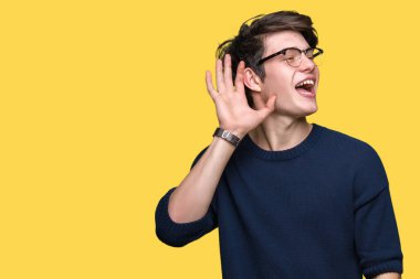 Bir işitme söylenti ya da dedikodu için dinleme kulak üzerinde el ile gülümseyen izole arka plan üzerinde gözlük takan yakışıklı delikanlı. Sağırlık kavramı.