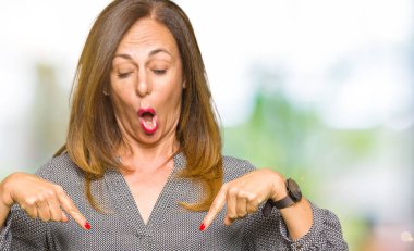 Reklam, sürpriz yüz ve açık ağız gösterilen güzel orta yaş iş kadını ile aşağı işaret parmak