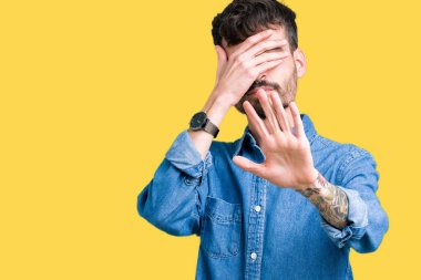 Genç yakışıklı adam izole elleriyle gözlerini kapsayan arka plan ve stop jest ile acı ve korku ifadesi. Utandım ve negatif kavramı.