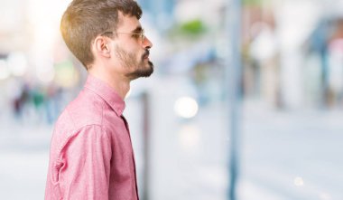 Genç yakışıklı adam giyen güneş gözlüğü izole arka tarafına, seyir üzerinde dinlenmek doğal yüz emin gülümseme ile pozuyla profili.