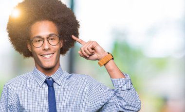 Bir parmak, harika bir fikir ya da düşünce, iyi hafıza ile baş gösteren gülen genç Afro-Amerikalı iş adamı afro saç giyen ile gözlük