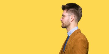 Genç yakışıklı zarif adam yan, doğal yüz emin gülümseme ile pozuyla profil rahatla aramaya güneş gözlüğü takıyor.