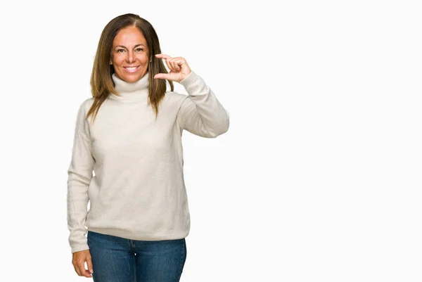 美しい中年分離背景笑顔と自信を持ってサイズ記号を見ながら指とカメラをやって手でジェスチャーを冬のセーターを着ている大人の女性 測定概念 — ストック写真