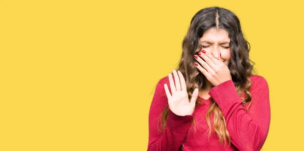 年轻的漂亮女人穿着红色毛衣 闻到一些臭气熏天 难以忍受的气味 用手指在鼻子上屏住呼吸 臭味概念 — 图库照片