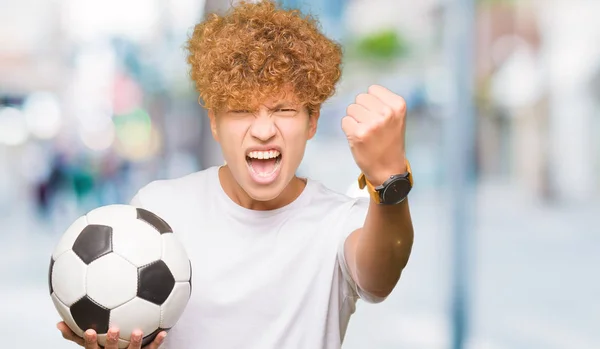 Joven Hombre Guapo Sosteniendo Balón Fútbol Molesto Frustrado Gritando Con — Foto de Stock
