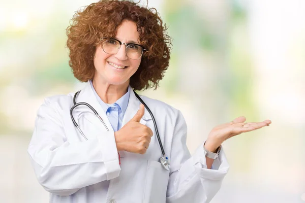 中间的资深医生妇女在孤立的背景显示手掌手和做确定的手势竖起来 微笑着快乐和开朗 — 图库照片