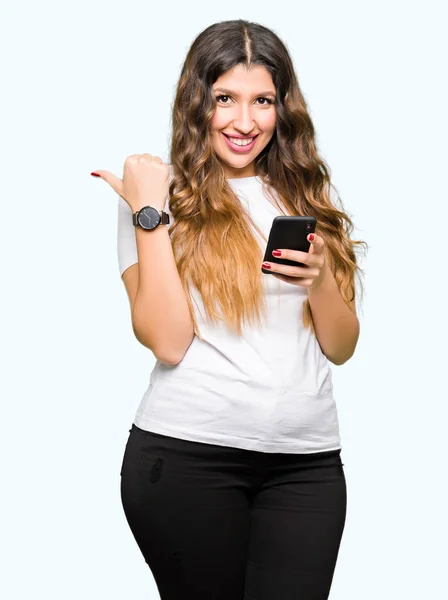Young Adult Woman Using Smartphone Pointing Showing Thumb Side Happy — Stock Photo, Image
