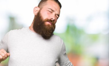 Rahat kazak giyen genç sarışın adam geri uzanan, yorgun ve rahat, Uykulu ve erken sabah için esneme