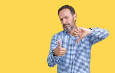 Yakışıklı orta yaş izole arka plan yapmaya başparmak yukarı ve aşağı, anlaşmazlık ve anlaşma ifade üzerinde zarif komuta sizde. Deli çatışma