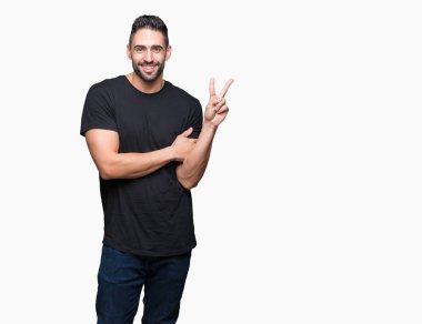 Mutlu yüz zafer işareti yaparken kameraya göz kırpıyor ile gülümseyen izole arka plan üzerinde genç yakışıklı adam. İki numaralı.