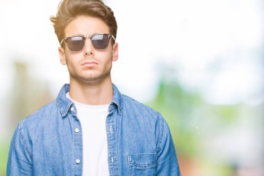 Genç yakışıklı adam sorunu nedeniyle izole arka plan şüpheci ve sinir, papatyanın üzgün üzerinde güneş gözlüğü takıyor. Negatif kişi.