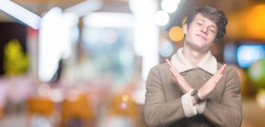 Yakışıklı delikanlı izole arka plan ret ifade geçiş kollarına eksi işareti, kızgın surat yapıyor kış palto giyiyor