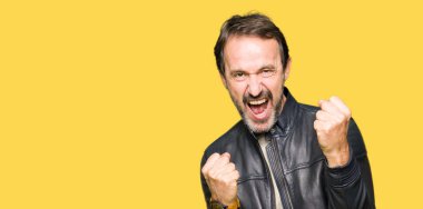 Siyah deri giyen orta yaş yakışıklı adam ceket çok mutlu ve heyecanlı kaldırdı Kollarını açarak kazanan jest yapıyor, gülümseyen ve başarı için çığlık. Kutlama kavramı.