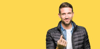 Yakışıklı adam giyen kış ceket Beckoning gel burada mutlu ve gülümseyerek el davet ile jest