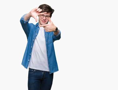 Elle yapma çerçeve ve parmakları ile mutlu yüz gülümseyen izole arka plan üzerinde gözlük takan yakışıklı delikanlı. Yaratıcılık ve Fotoğrafçılık kavramı.