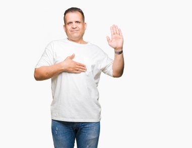 Orta Çağ Arap adam wearig beyaz t-shirt üzerinde izole arka plan üzerine el ile göğüs ve açık palmiye, bir sadakat vaat yemini yapma