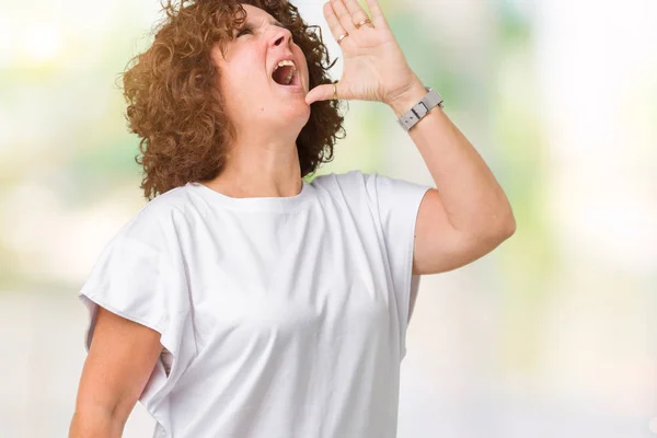 美しい中間エイガー年配の女性分離背景 2Shouting に白い シャツを着て 口に手の側に大声で叫んでいます 通信の概念 — ストック写真