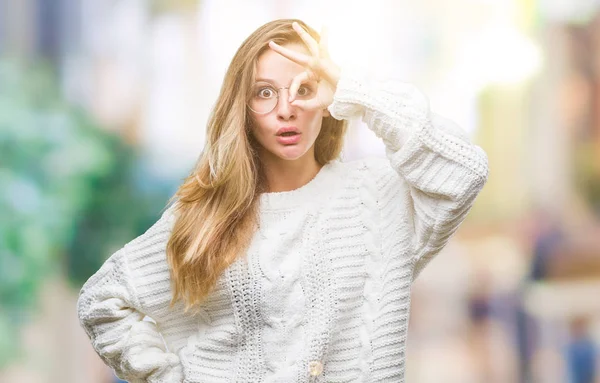 年轻美丽的金发碧眼的女人穿着冬季毛衣和太阳镜在孤立的背景做确定的手势震惊与惊讶的脸 眼睛通过手指看 不相信的表达 — 图库照片
