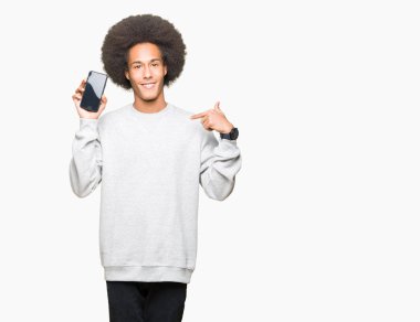 Afro saçlı genç afro-amerikan adam sürpriz yüz kendini parmak işaret ile akıllı telefon ekranı gösteren