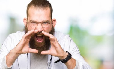 Sakal giyen tıbbi ceket ile genç sarışın doktor adam ağız üzerinde eller ile yüksek sesle öfkeli çığlık