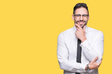 Emin çapraz kollar ve çeneme kaldırdı el ile gülümseme ile kameraya bakarak izole arka plan üzerinde gözlük takan genç yakışıklı iş adamı. Pozitif düşünce.