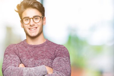 Yakışıklı delikanlı üzerinde gözlük takan mutlu yüz ile gülümseyerek kameraya seyir silah geçti arka plan izole. Olumlu bir kişi.