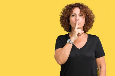 Izole arka plan üzerinde güzel orta ager kıdemli kadın dudaklarında parmak ile sessiz olmak isteyen. Sessizlik ve gizli kavram.