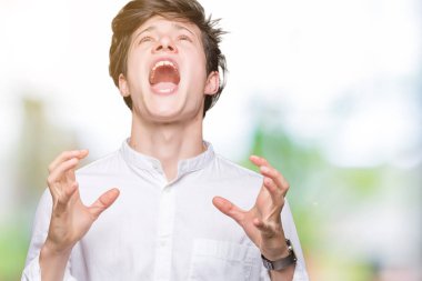 Genç yakışıklı iş adamı izole arka plan çılgın ve kızgın bağırarak ve agresif ifade ve silah kaldırdı bağırıyor. Hayal kırıklığı kavramı.