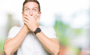 Yakışıklı adam ağız hata için elleriyle kapsayan şok Casual beyaz t-shirt giyiyor. Gizli kavramı.