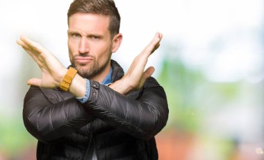 Kış lık palto giyen yakışıklı adam Reddi ifadesi nin kollarını geçerek olumsuz işaret, kızgın surat