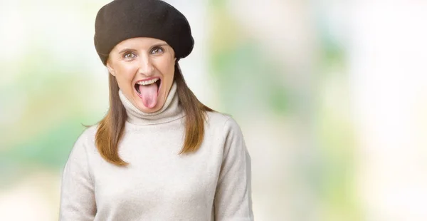 中年熟女の身に着けている冬のセーターと舌を付着分離の背景にベレー帽を面白い表現に満足 感情の概念 — ストック写真