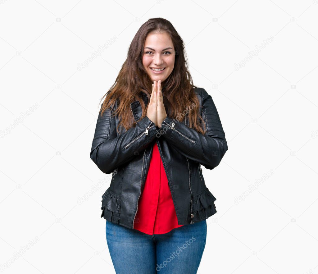 Beautiful plus size young woman wearing a fashion leather jacket over isolated background praying with hands together asking for forgiveness smiling confident.