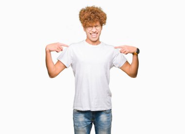 Yüzünde gülümseme ile kendinden emin görünüyorsun, kendini gururlu ve mutlu parmakları ile işaret gözlüklü afro saçlı genç yakışıklı adam.