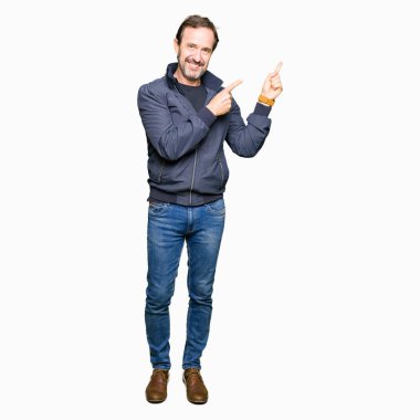 Orta yaş yakışıklı adam gülümseyerek ve iki elleri ve parmakları ile tarafına işaret kamera bakarak bir ceket.