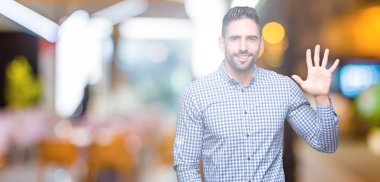 Yakışıklı delikanlı gösterilen ve parmakları ile işaret izole arka plan üzerinde beş kendinden emin ve mutlu gülümseyerek iken numara.