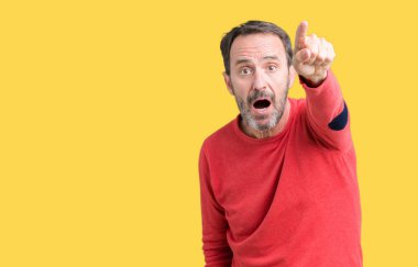 Yakışıklı orta yaş ağarmış komuta sizde üzerinde giyen kış kazak izole arka plan ile sürpriz devam et, parmakla ağız açık ifade, önünde bir şey hayret