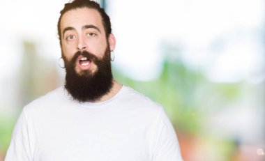 Genç uzun saçlı adam ve futbol futbol topu bir sürpriz yüz, korkuyor ve heyecanlı korku ifadesi ile şok korkmuş tutan ayı