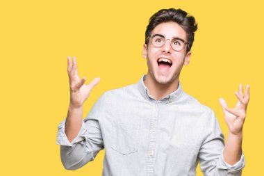 Üzerinde gözlük takan genç yakışıklı adam arka plan deli izole ve deli bağırarak ve agresif ifade ve silah kaldırdı bağırıyor. Hayal kırıklığı kavramı.