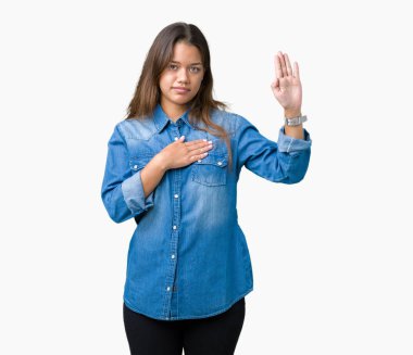 Üzerinde mavi kot gömlek giyen genç güzel esmer kadın izole arka plan göğüs ve bir sadakat sözü yemin yapma avuç, el ile küfür