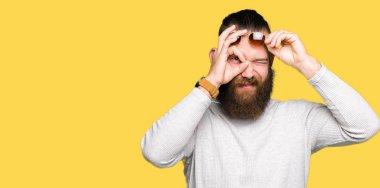 Genç hipster adam giyen güneş gözlüğü el gülümseyen, ok jest yapıyor göz parmakları ile mutlu yüz üzerinden seyir.