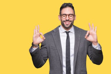 Genç yakışıklı iş adamı izole arka plan üzerinde dinlenmek ve gülümseyen gözlerle kapalı parmak jestle meditasyon yapıyor. Yoga kavramı.