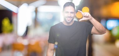 Yakışıklı genç gülümseyen izole arka plan ve süre seyir ve kamera boyutu işaret parmaklarıyla yapıyor el ile kendinden emin eller üzerinde. Ölçü kavramı.